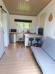 a room with a bed and a kitchen with a counter at Cabaña Esencia in Maldonado +2 photos
