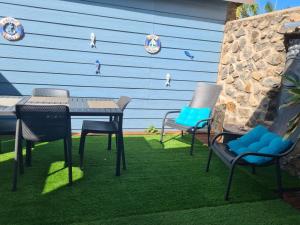a patio with a table and chairs in front of a wall at Le Pavillon du trou d'eau in La Saline les Bains