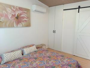 a bedroom with a bed and a painting on the wall at Cabaña Esencia in Maldonado
