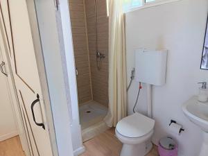 a white bathroom with a toilet and a shower at Cabaña Esencia in Maldonado