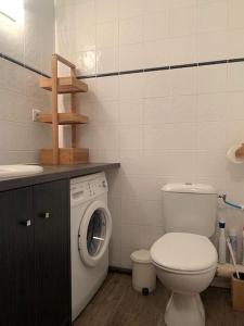 a bathroom with a toilet and a washing machine at Studio Brides les bains in Brides-les-Bains
