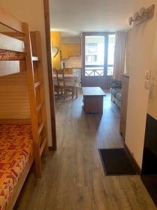 a bedroom with a bunk bed and a living room at Studio Brides les bains in Brides-les-Bains