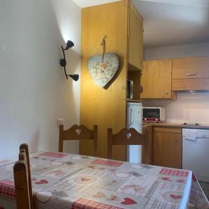 a kitchen with a heart clock on the wall at Studio Brides les bains in Brides-les-Bains