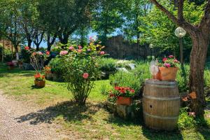 a garden with flowers in pots and a barrel at La Coroncina Lodging in Siena