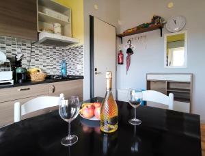 a bottle of wine sitting on a table with two wine glasses at Casa Bonifacio in Scalea