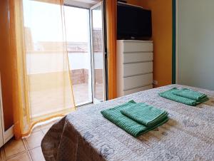 a bedroom with a bed with two green towels on it at Casa Bonifacio in Scalea +9 photos