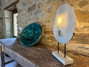 two metal objects sitting on a table next to a stone wall at Villa Amici Apartment in Fontignano