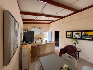 a living room with a table and a kitchen at Casa de campo El Bonao in Higuey