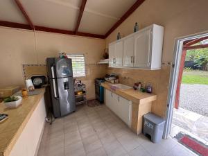 a small kitchen with a refrigerator and a sink at Casa de campo El Bonao in Higuey +9 photos