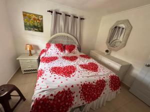a bedroom with a red and white bedspread with hearts at Casa de campo El Bonao in Higuey