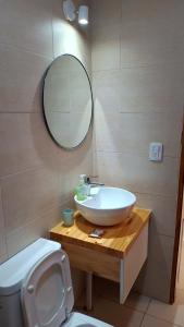a bathroom with a sink and a toilet and a mirror at Once Reinas Departamentos in San Rafael