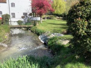 a stream in a yard with a bridge at Bellows Mill in Dunstable