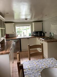 a kitchen with white cabinets and a table in it at Bellows Mill in Dunstable