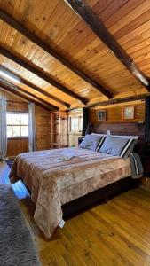 a large bed in a room with a wooden ceiling at Morada das Estrelas in Cambará