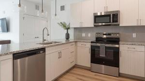 a kitchen with white cabinets and stainless steel appliances at Landing Modern 2BD Gym Clubhouse in Longmont