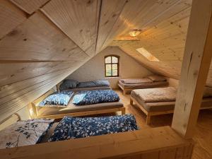 an attic bedroom with two beds in a room at Krušnohorský Poutník in Kovářská