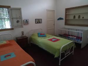 a bedroom with two beds and a window at Casona El Olivo in Villa Krause