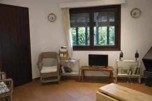 a living room with a chair and a television at Casa amb llar de foc - Casa Anina in Montsonis
