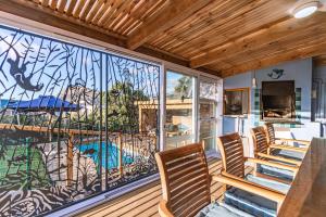 a screened in porch with chairs and a large window at The Mermaid's Tail in Pringle Bay