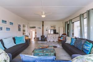 a living room with a couch and a table at The Mermaid's Tail in Pringle Bay