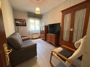 a living room with a couch and a tv at Norte Astur in Langreo