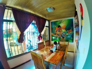 a dining room with a wooden table and a window at Hostal La Esperanza in Leticia