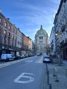 an empty city street with cars parked on the road at Hotel Albert in Brussels