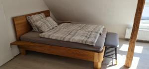 a bed with a wooden frame in a room at Pension am Bach Prinz Charming in Fuldatal