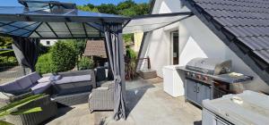 a patio with a grill and a barbecue on a deck at Pension am Bach Prinz Charming in Fuldatal