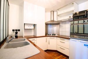 a kitchen with a sink and a stove top oven at Cristalys Loveroom & Spa in Montpellier