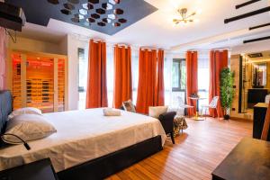 a bedroom with a large bed with orange curtains at Cristalys Loveroom & Spa in Montpellier