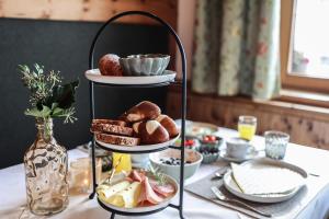 a three tiered tray of bread and pastries on a table at Hotel Geisler Tulfes in Tulfes +35 photos