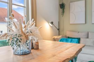 a vase of flowers sitting on a wooden table at dreamfactory Residences - Wine Escapes # 3BR Suite in Langenlois