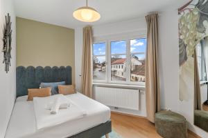 a bedroom with a white bed and a large window at dreamfactory Residences - Wine Escapes # 3BR Suite in Langenlois +21 photos