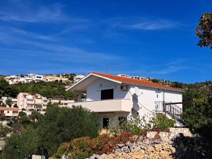 a white house on top of a hill at Apartmani Barba Sevid in Sevid