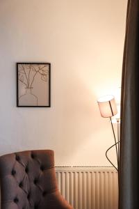 a living room with a chair and a lamp at Hotel Geisler Tulfes in Tulfes