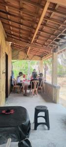 a group of people sitting at a table on a patio at Abrigo de Montanha Quixadá in Quixadá