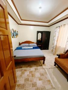 a bedroom with a bed and a couch at Romar's Place Roxas Orientl, Mindoro in Roxas