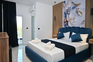 a bedroom with a blue and white bed with towels on it at Vila Bashkim in Ksamil