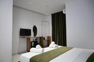 a hotel room with two beds and a tv at Vila Bashkim in Ksamil
