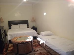 a bedroom with two beds and a bathtub in it at Dar Tissila in Marrakesh