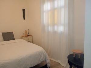 a bedroom with a white bed and a window at Dar Tissila in Marrakesh
