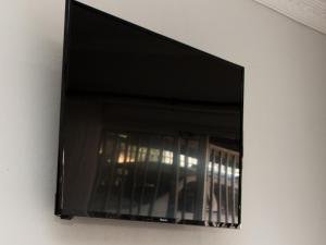 ein Flachbildfernseher, der an einer Wand hängt in der Unterkunft Rest4Sure in Ashton