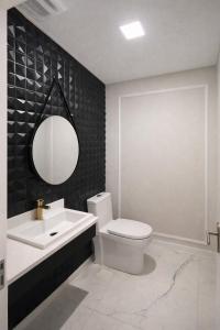 a bathroom with a sink and a toilet and a mirror at Summerview novo , 2 piscinas e 2 jacuzzis, 2 quartos Novo! in Itapema
