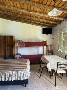 a room with two beds and a table and a tv at Amanecer en Cuyo in San Rafael