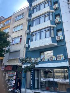 a man walking in front of a blue building at Güven Suit Otel in Istanbul
