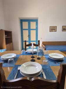 a table with plates and glasses on top of it at La Casetta Sul Corso in Ischia Town
