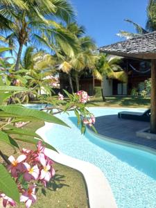 a resort with a swimming pool and palm trees at Casa meravigliosa vicino alla spiaggia con grande piscina e giardino in Beberibe