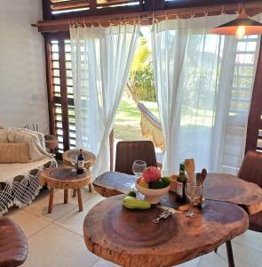 a living room with two tables and a table with fruit on it at Casa meravigliosa vicino alla spiaggia con grande piscina e giardino in Beberibe