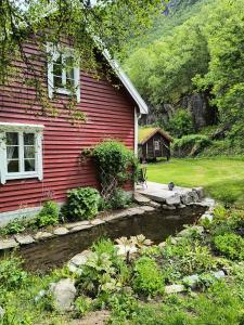 a red house with a pond in front of it at Flintegården Kårhus in Borgund +12 photos